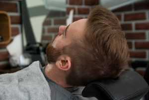 Mannelijke schoonheidsspecialist aan het werk in Salon We Care, specialist in baardverzorging en huidverzorging voor mannen