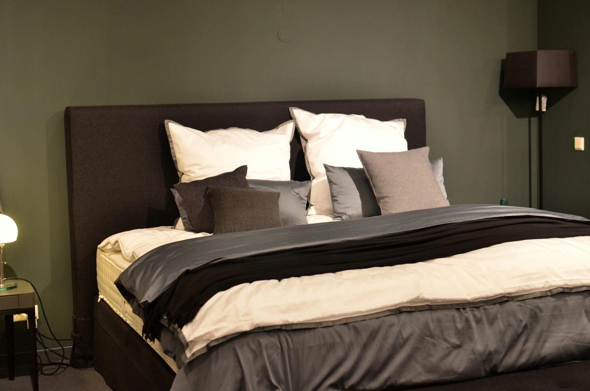 Iemand liegt comfortabel in een bed en kiest het juiste matras voor duurzame ondersteuning en langdurig comfort
